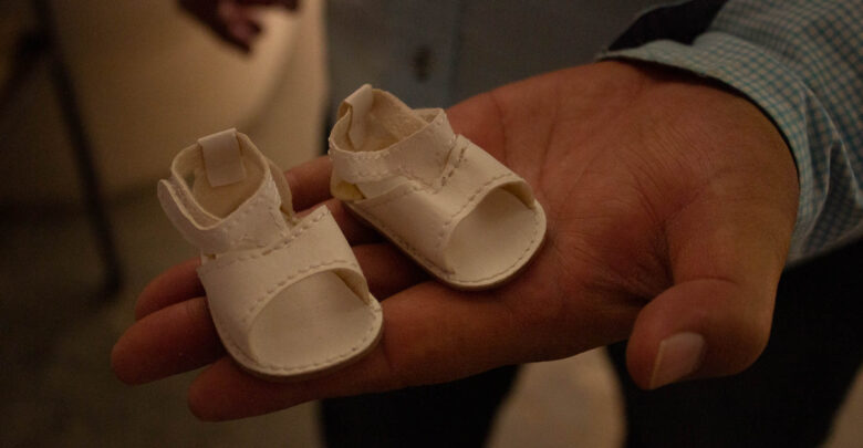 El Sr. Francisco sostiene un par de zapatos de muñeca, un accesorio importante en el juguete.