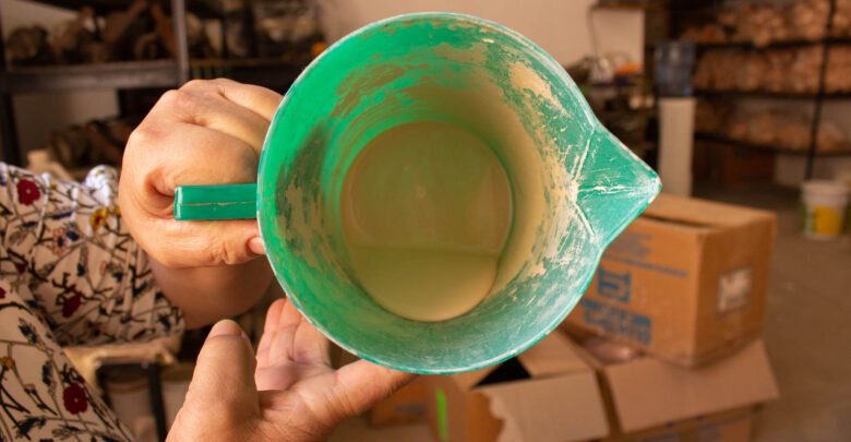 La Sra. Lidia sostiene una jarra con vinil, material con el que se crean las partes de las muñecas.